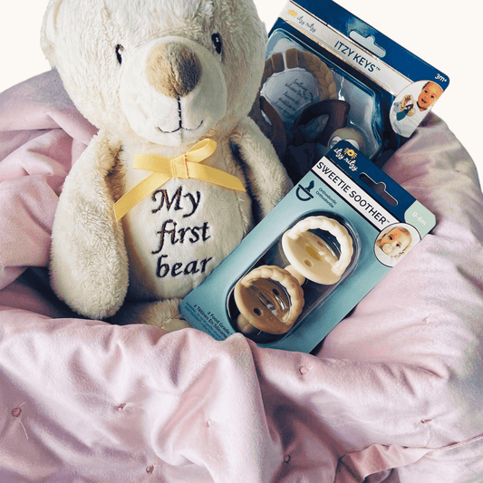 Soft and cuddly baby blanket set with plush teddy bear and infant care essentials in gift basket.