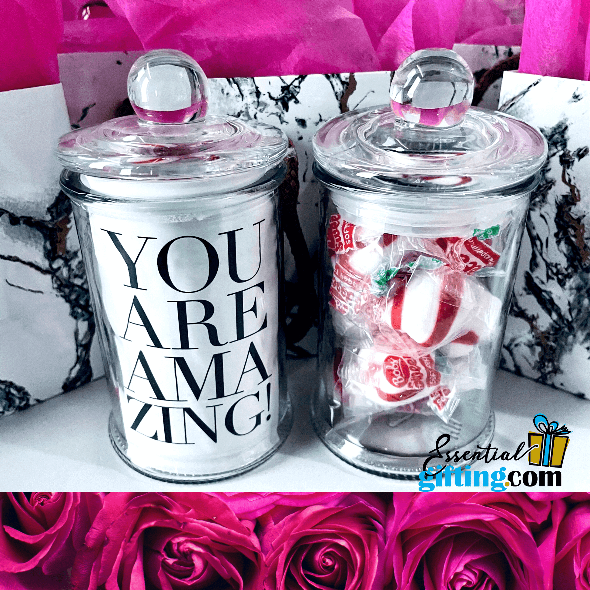 Decorative candy jars with "You are amazing" text, filled with red and white peppermint candies, set against a backdrop of vibrant pink roses.