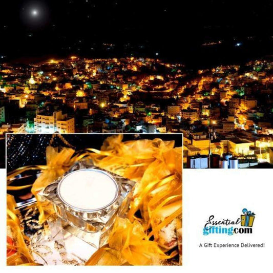 Crystal candle holder with glowing yellow tealights, against a backdrop of a vibrant city lit up at night.