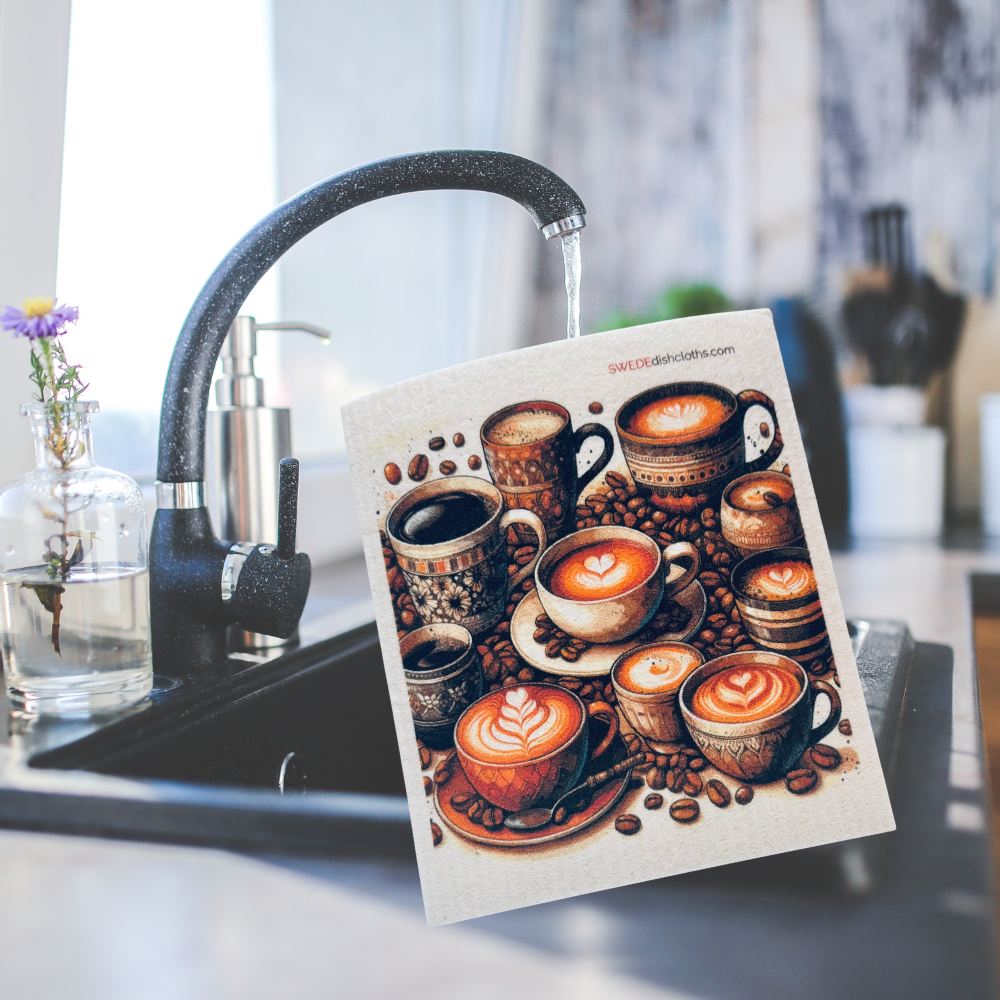 A square art print featuring a detailed coffee cup illustration with latte art and coffee beans, held in front of a kitchen sink with running water and a modern faucet.