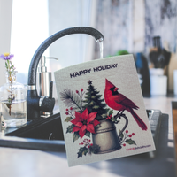 Thumbnail for A square kitchen towel with a Christmas holiday design is hanging from a black faucet in a kitchen sink. The towel features a red cardinal, a poinsettia, a Christmas tree, and the text 'HAPPY HOLIDAY'.