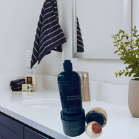 Thumbnail for Bathroom counter with blue bottle, striped towel, and plant