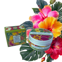 Thumbnail for Tahiti Body Butter product shown with its green floral box and round tub jar, styled with tropical hibiscus flowers and green leaves on a white background.