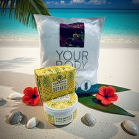 Thumbnail for Pineapple body butter and wrap on a sandy beach with flowers and shells.