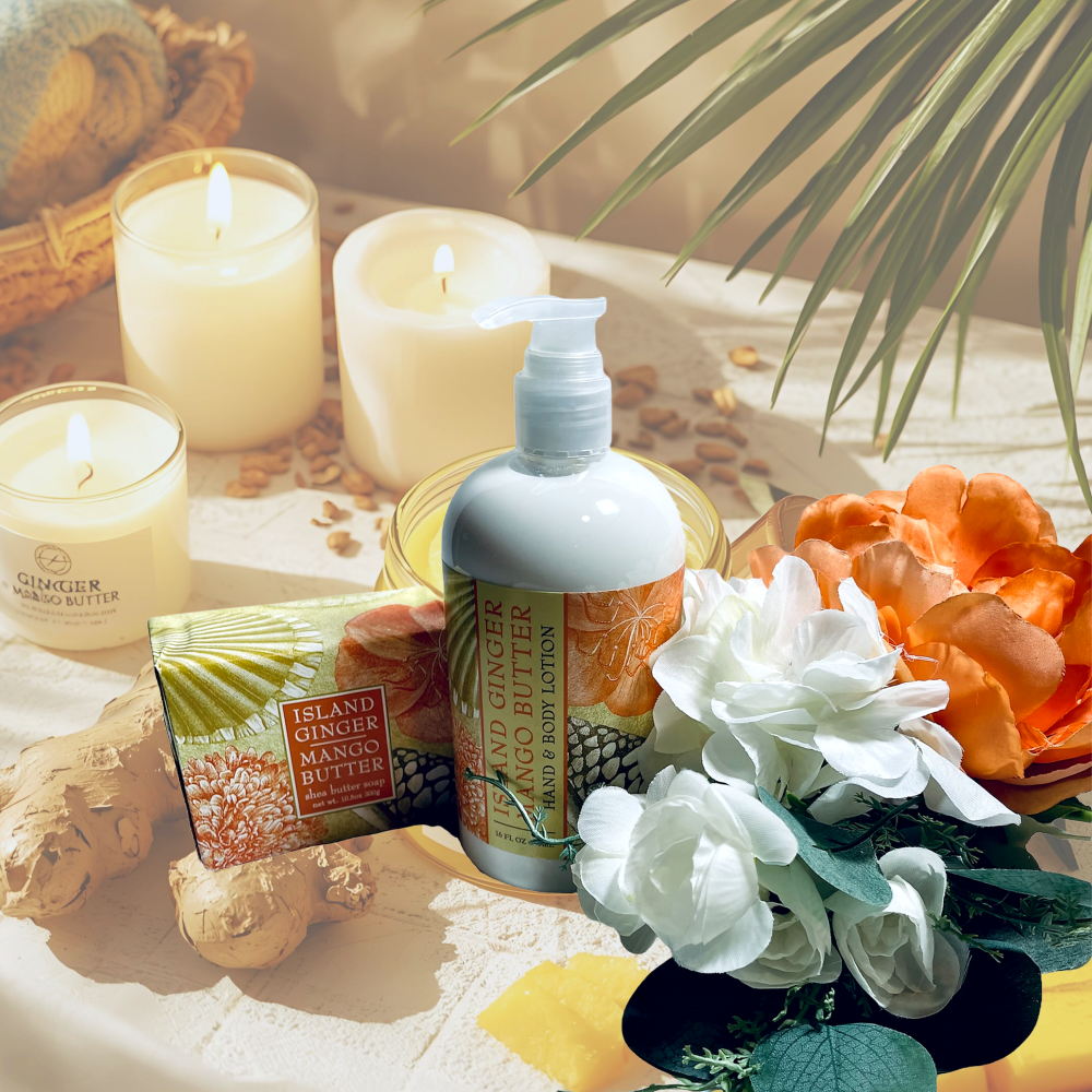Bottle of Island Queen Ginger Mango Butter with candles and flowers on a table