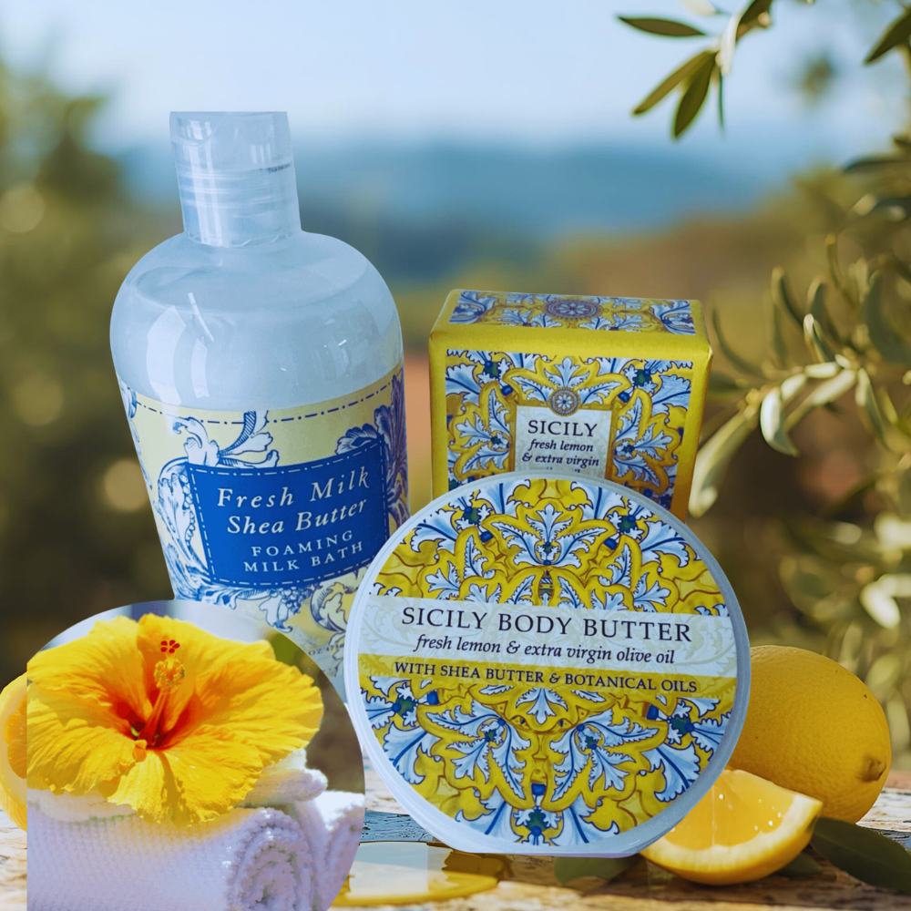 Sicily-themed skincare products with lemons and a yellow flower on a blurred natural background