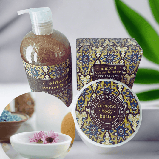 Almond Cocoa Butter Bath & Body Set by Essentialgifting, featuring a bottle of exfoliating gel and a jar of body butter on a floral patterned background.