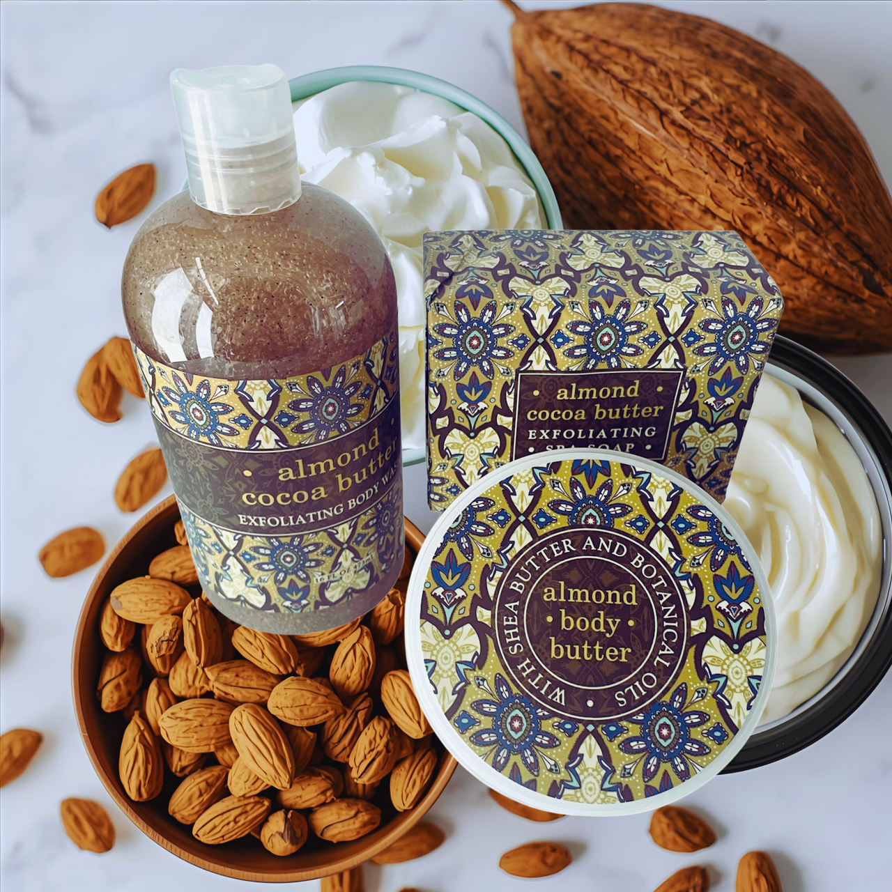 Almond and cocoa butter products including a bottle, box, and body butter on a white background with almonds and a coconut.