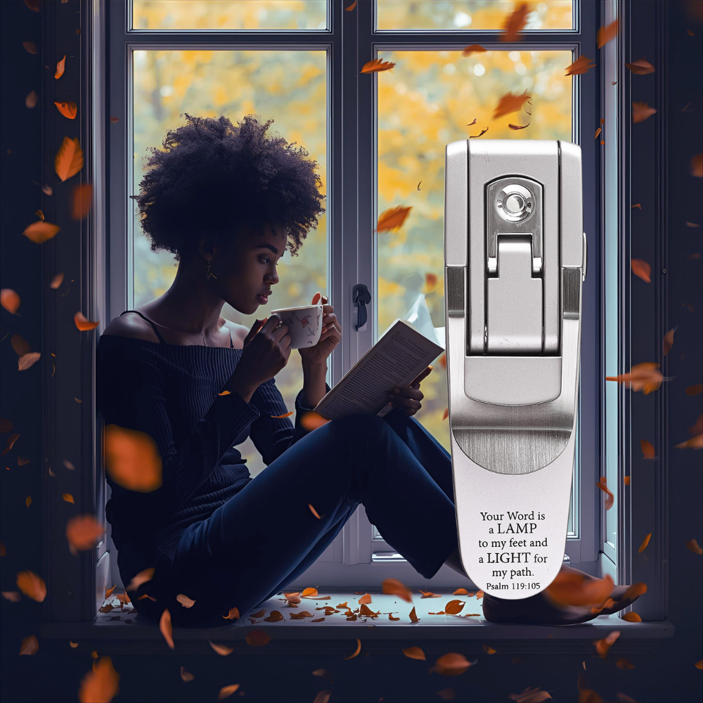 Woman reading a book by a window with autumn leaves falling, next to a door handle.
