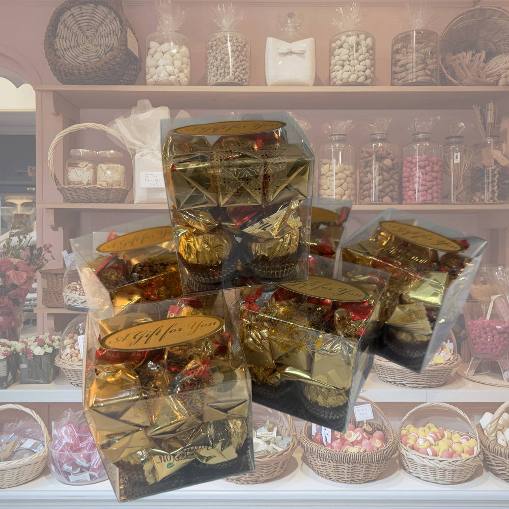 Gift-wrapped chocolates on a counter with shelves of candies in the background