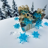 Thumbnail for Decorative gift boxes with gold ribbons on a snowy background with blue snowflake decorations.