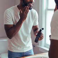 Thumbnail for Man applying aftershave to his face in a bathroom
