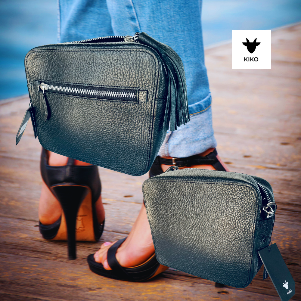 Black handbag with fringe detail on a wooden floor, Kiko brand visible