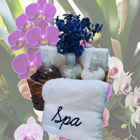 Thumbnail for Spa-themed gift basket with towels, bottles, and flowers on a floral background