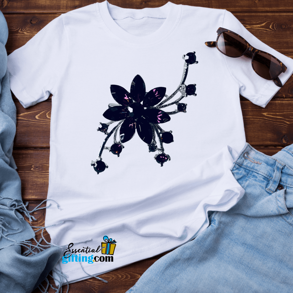 Elegant floral brooch pin on white t-shirt against wooden background