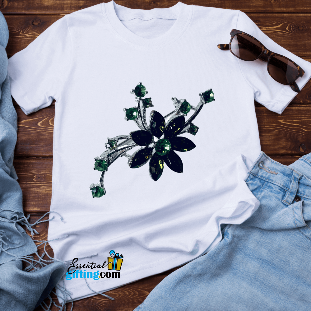 Elegant floral brooch pin in white t-shirt on wooden background.