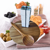 Thumbnail for Acacia wood charcuterie board with assorted snacks, including olives, crackers, and condiments, along with a cheese slicer on a rustic table setting.