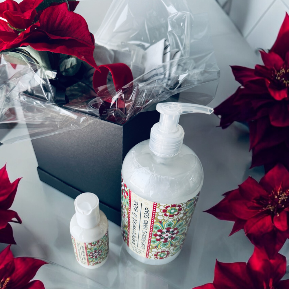 Handsoap and Lotion with decorative labels on a surface with red flowers.