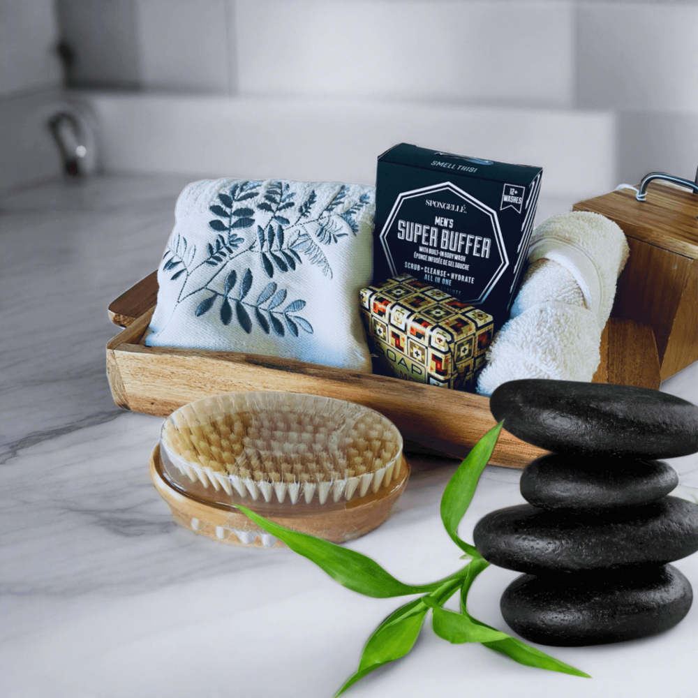 Luxurious men's grooming set with plush towel, natural bristle brush, and botanical-infused bath products on wooden tray.