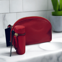 Thumbnail for Red leather pouch with a matching red cylindrical item on a white surface.