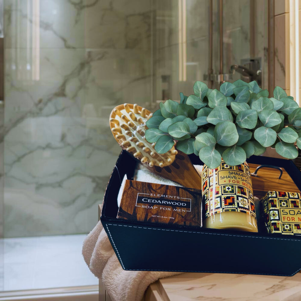 Gift set with soap, brush, and plant in a decorative box on a marble surface.