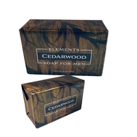 Thumbnail for Two rectangular bars of Elements Cedarwood Soap for Men in matching dark brown wood-grain packaging, shown on a plain white background.