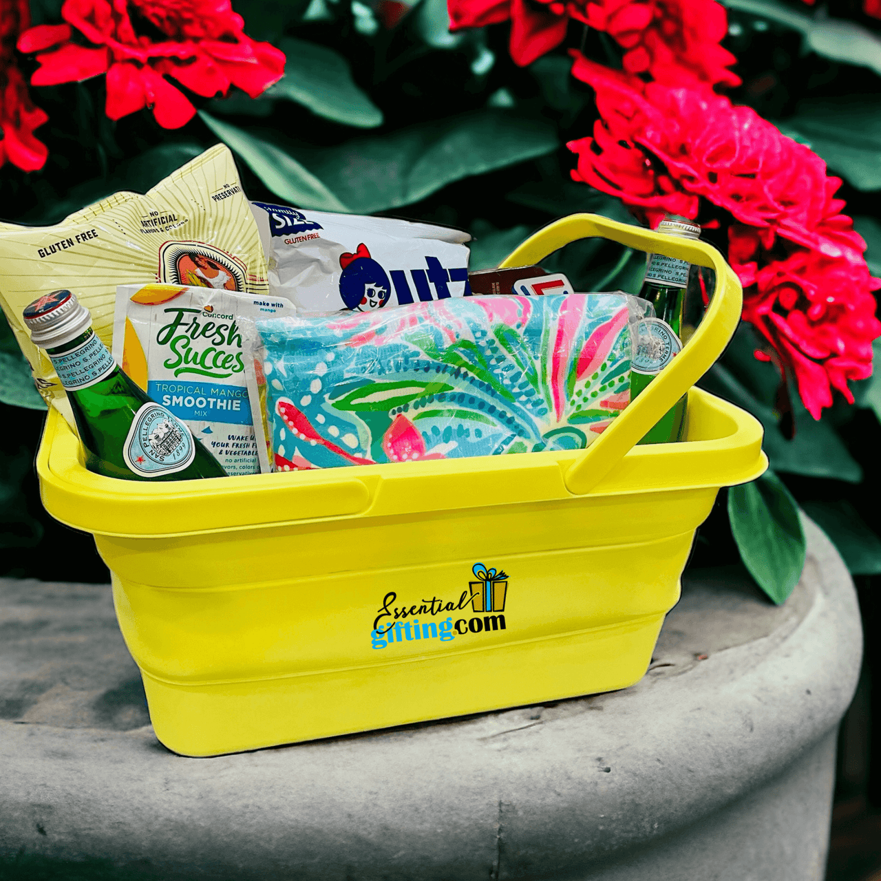 Personalized Lifestyle Box: An assortment of practical essentials nestled in a vibrant yellow gift basket, surrounded by lush red blooms.