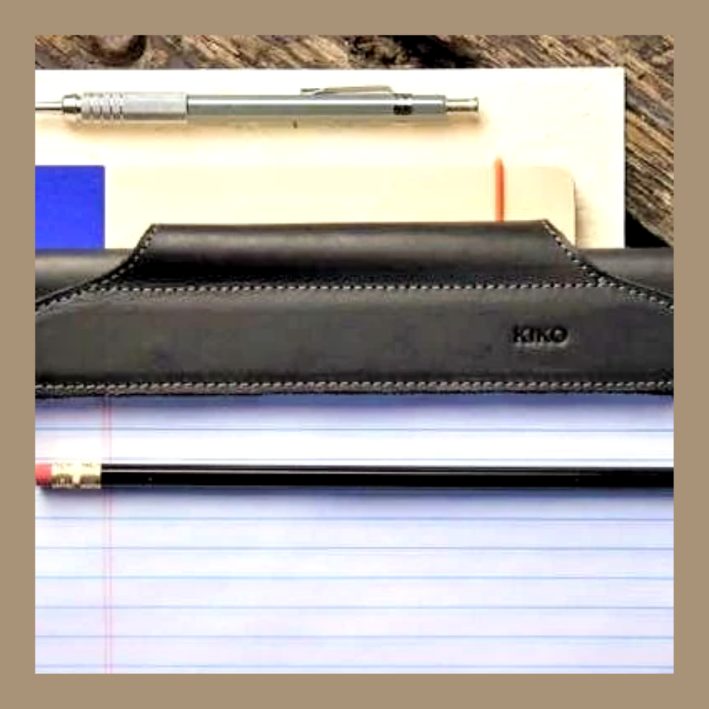Black leather pen holder with a pen on lined paper