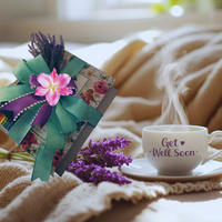 Thumbnail for Get Well Soon card with flowers and a steaming cup of tea on a soft surface.