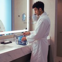 Thumbnail for Man in hotel bathroom with travel toiletry bag.