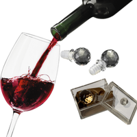 Thumbnail for Wine bottle pouring red wine into a glass with two diamond-shaped wine stoppers and a box of chocolates.